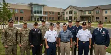 Veterans smiling in front of new housing and healthcare facilities, symbolizing updated benefits.