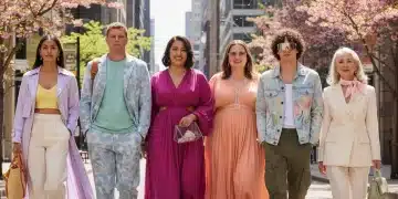 Stylish individuals showcasing Spring 2026 fashion trends on a sunny city street, featuring diverse outfits and modern architecture.